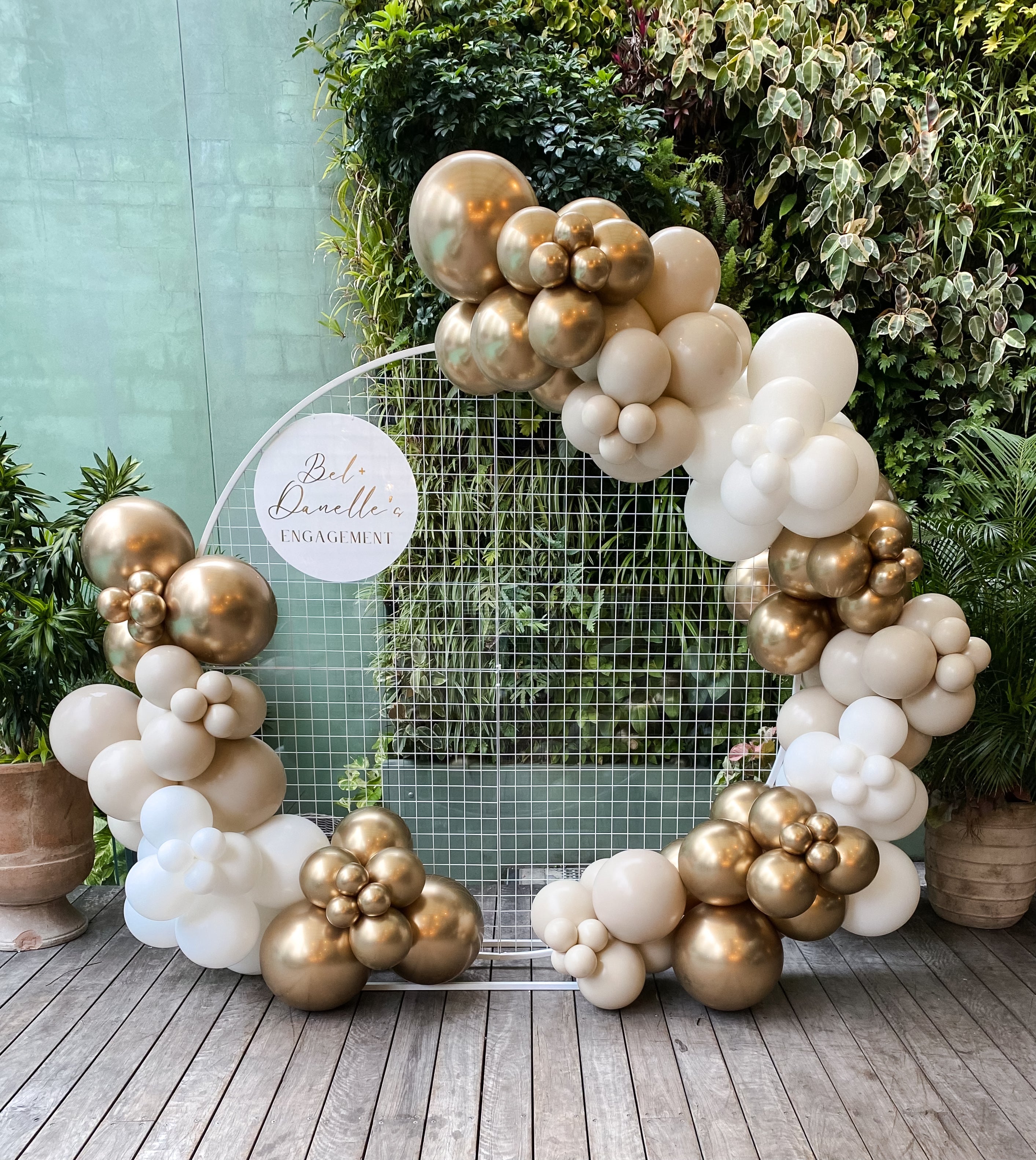 Gold Coast birthday party balloon hoop decor setup with sand and gold balloons